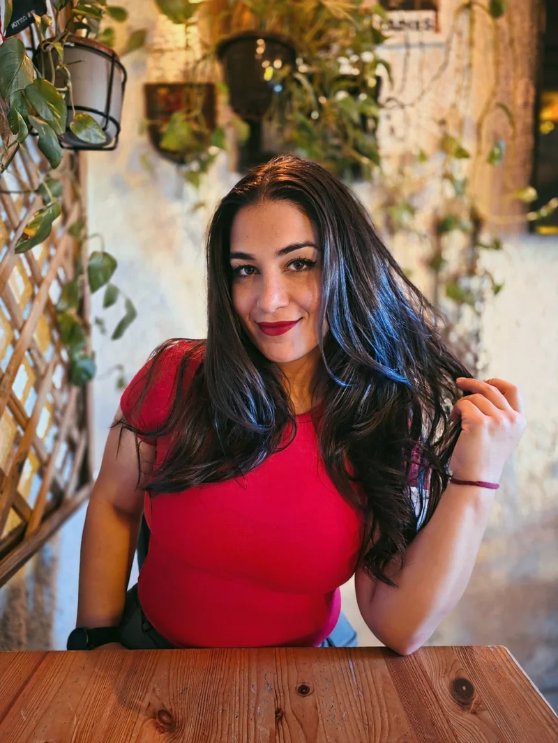 Smiling nutrition professional sitting at a cafe with plants in the background